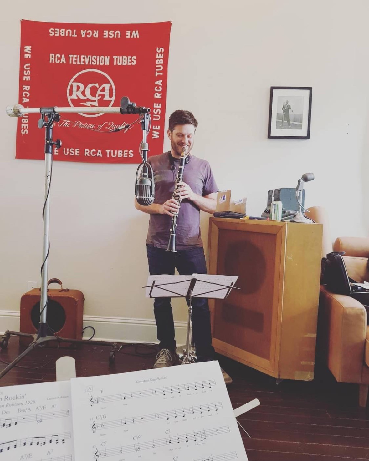 Jonathan Greene playing clarinet in a recording studio beside red RCA wall art